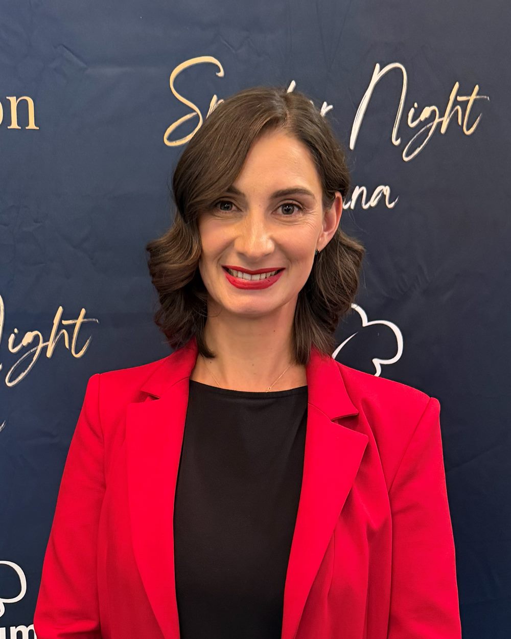 Eva Buttazoni im roten Blazer, lächelnd